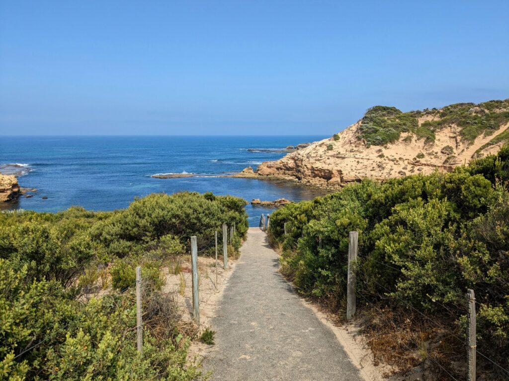 Paved trail down to Diamond Bay in Sorrento, Victoria, with rocky coastline and ocean in the background