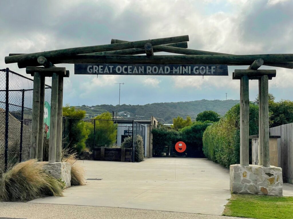 Great Ocean Road Mini Golf, with sign and wooden entranceway. Cloudy skies.