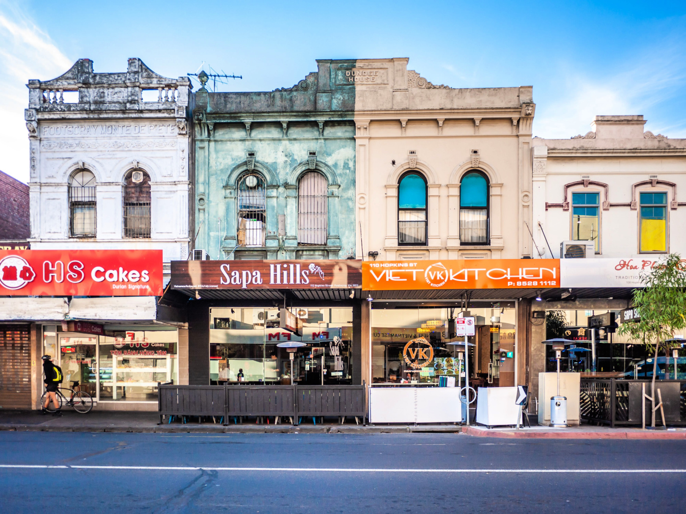 Faded Victorian architecture lines a street in Footscray, with the ground floor of each having been converted into a series of Vietnamese restaurants.